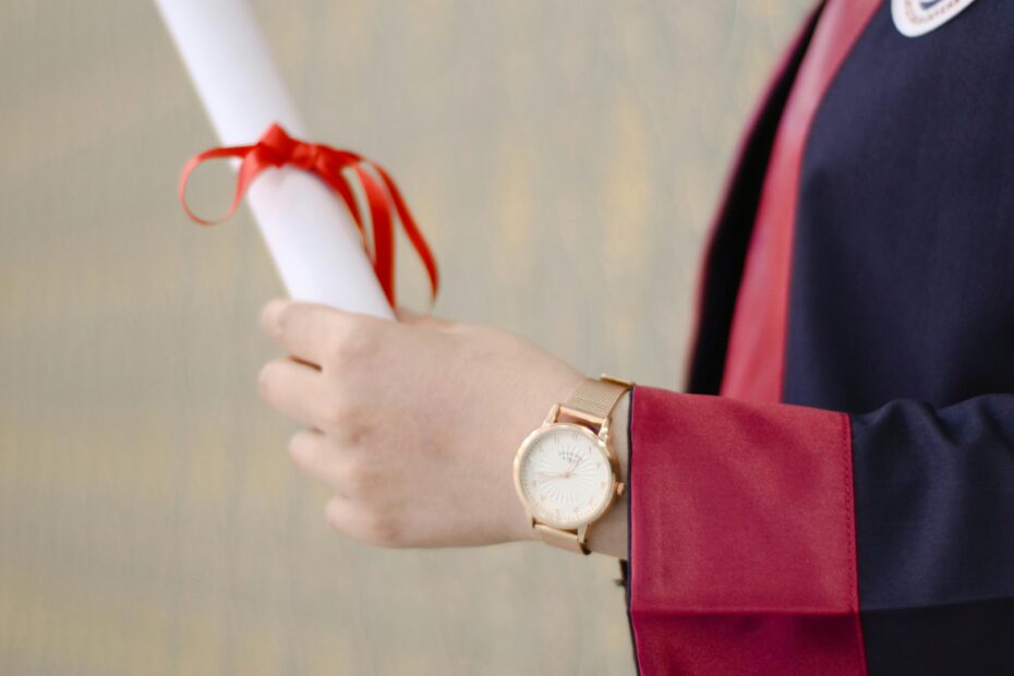 A close-up of a graduate's hand holding a diploma, symbolizing success and achievement.