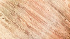 Close-up of a rustic wooden texture with detailed grain patterns, perfect for backgrounds.