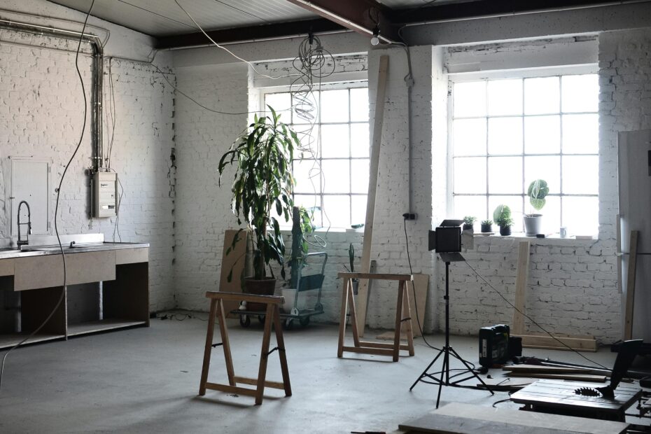 Interior of loft with brick wall with wires hanging on ceiling and tools for renovation works